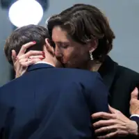 Emmanuel Macron kao da hvata Amelie Oudea Casteru za ruku dok ministar sporta ljubi predsjednika u vrat