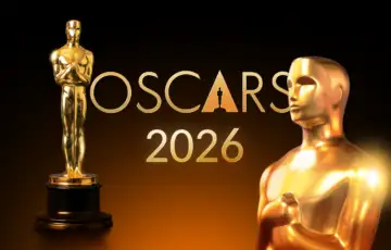 Gold oscar statuettes with the oscars 2026 logo on a dark background with a warm glow