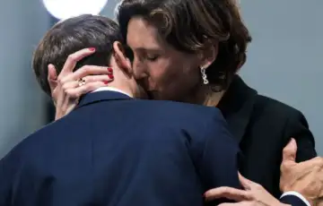 Emmanuel Macron kao da hvata Amelie Oudea Casteru za ruku dok ministar sporta ljubi predsjednika u vrat